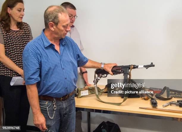 June 2018, Germany, Munich: Curator of the Store Room of the Public Prosecution Service, Anton Jofer, holding a confiscated MP40 at the press...