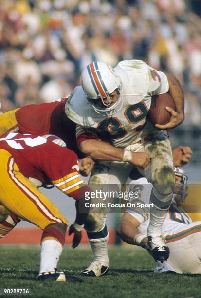 Running back Larry Csonka of the Miami Dolphins carries the ball and is hit by two Washington Redskins defenders January 14, 1973 during Super Bowl...