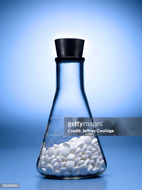 pills in beaker - artigos de vidro de laboratório - fotografias e filmes do acervo