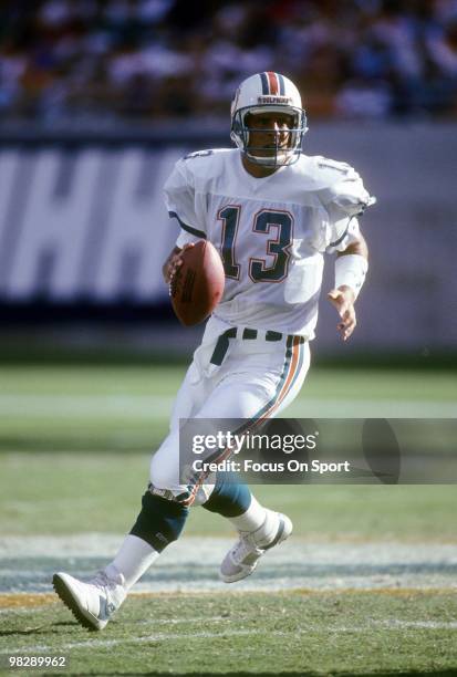 S: Quarterback Dan Marino of the Miami Dolphins rolls out to pass circa late 1980's during an NFL football game at Joe Robbie Stadium in Miami,...