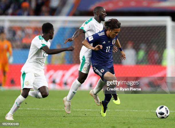 Takashi Usami of Japan is challenged by Youssouf Sabaly of Senegal during the 2018 FIFA World Cup Russia group H match between Japan and Senegal at...