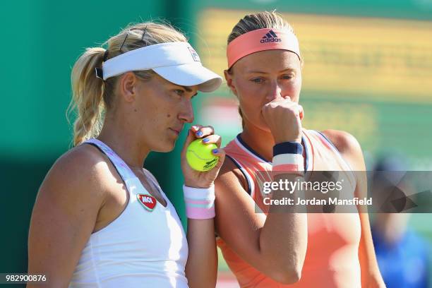 Kristina Mladenovic of France and Timea Babos of Hungary talk tactics during their doubles Final match against Elise Mertens of Belgium and Demi...