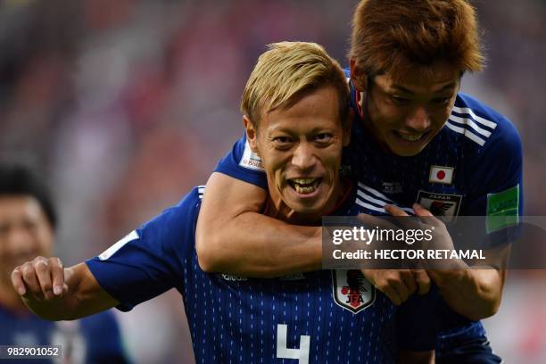 Japan's midfielder Keisuke Honda is congratulated by teammates after scoring his team's second goal during the Russia 2018 World Cup Group H football...