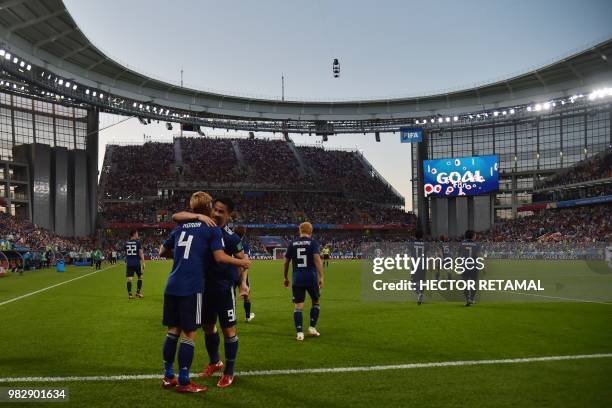 Japan's midfielder Keisuke Honda is congratulated by teammates after scoring his team's second goal during the Russia 2018 World Cup Group H football...