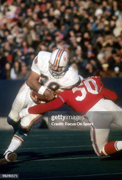 S: Running back Larry Csonka of the Miami Dolphins with the ball is hit by linebacker Jim Cheyunski of the New England Patriots circa mid 1970's...