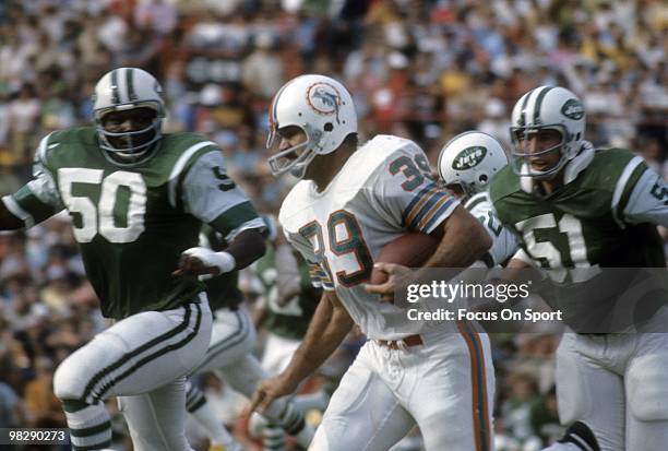 S: Running back Larry Csonka of the Miami Dolphins in action carries the ball chased by linebackers Ralph Baker and Michael Taylor of the New York...