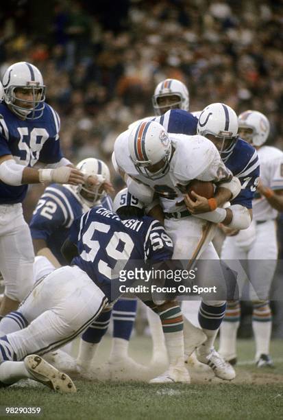 S: Running back Larry Csonka of the Miami Dolphins in action carries the ball is hit by linebacker Jim Cheyunski of the Baltimore Colts circa mid...