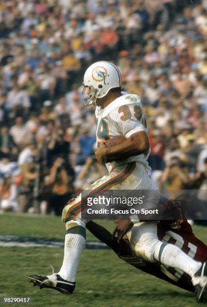Running back Larry Csonka of the Miami Dolphins runs through the tackle of defensive back Rosey Taylor of the Washington Redskins January 14, 1973...