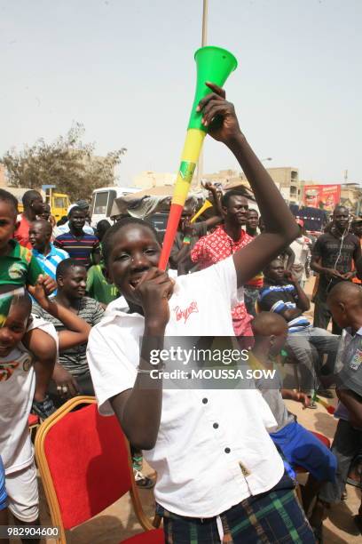 Child uses a vuvuzela as supporters watch on a giant screen the Russia 2018 World Cup Group H football match between Japan and Senegal on June 24,...
