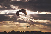 A man flying in the sky at a paraglider. Silhouette of a paraglider closeup
