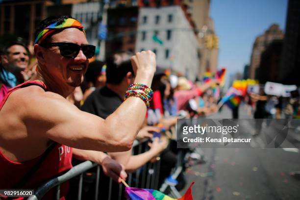 Revellers standing on Seventh Avenue watch the annual Pride Parade on June 24, 2018 in New York City. The first gay pride parade in the U.S. Was held...