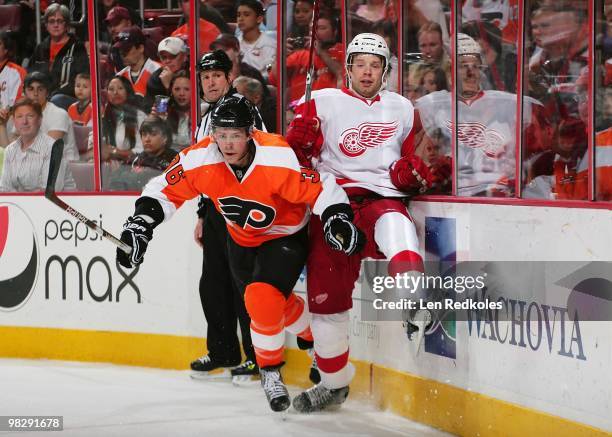 Darroll Powe of the Philadelphia Flyers checks Brad Stuart of the Detroit Red Wings along the boards on April 4, 2010 at the Wachovia Center in...