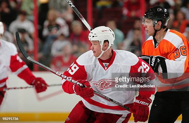 Darroll Powe of the Philadelphia Flyers skates with Jason Williams of the Detroit Red Wings on April 4, 2010 at the Wachovia Center in Philadelphia,...