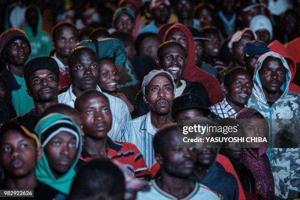 People in Kenya watch the Russia 2018 World Cup Group H football match between Japan and Senegal on a giant display near a sports betting company in...