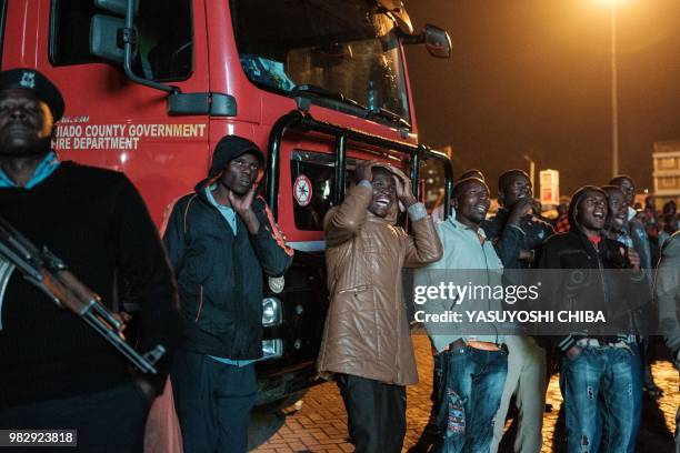 People in Kenya watch the Russia 2018 World Cup Group H football match between Japan and Senegal on a giant display near a sports betting company in...