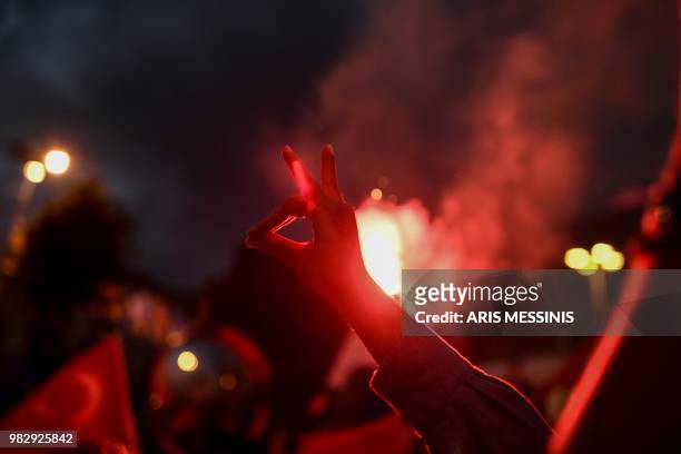 Person makes a four-finger sign as people react in the streets, near the Justice and Development Party headquarters in Istanbul, on June 24 during...