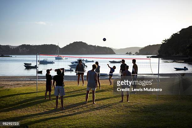 teenagers playing volleyball game on beachfront - bay of islands new zealand stock pictures, royalty-free photos & images
