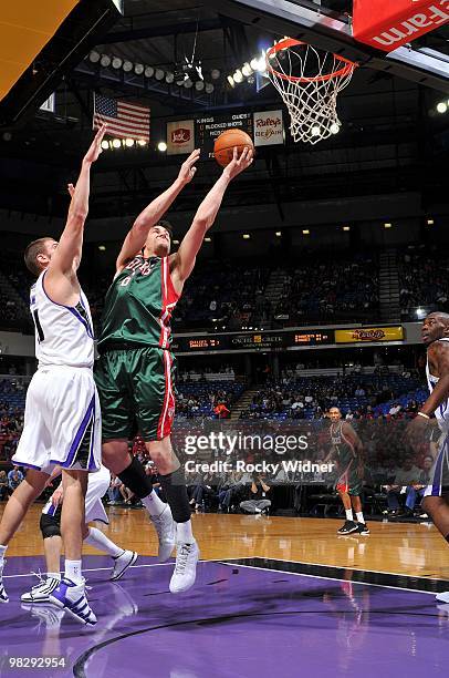 Andrew Bogut of the Milwaukee Bucks shoots a layup against Spencer Hawes of the Sacramento Kings during the game at Arco Arena on March 19, 2010 in...