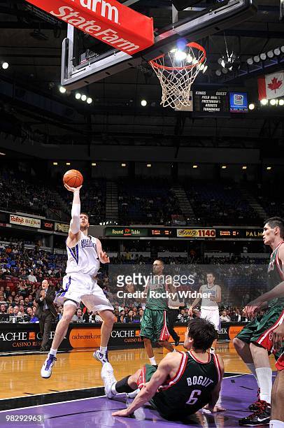 Andres Nocioni of the Sacramento Kings goes up for a shot against Andrew Bogut and Brandon Jennings of the Milwaukee Bucks during the game at Arco...