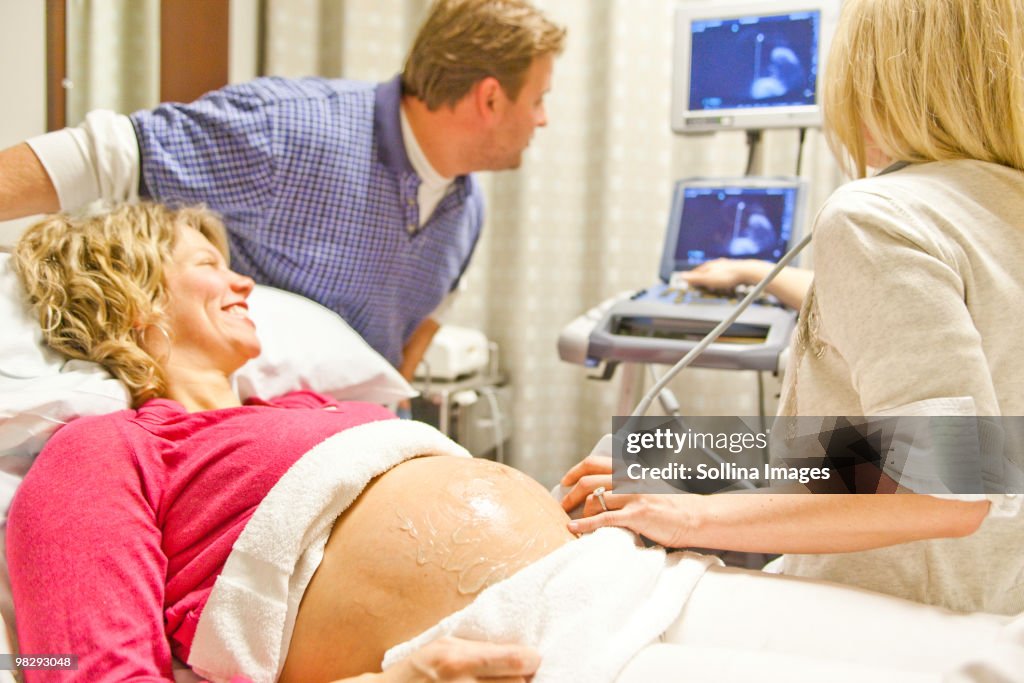 Man and woman watching monitor during sonogram