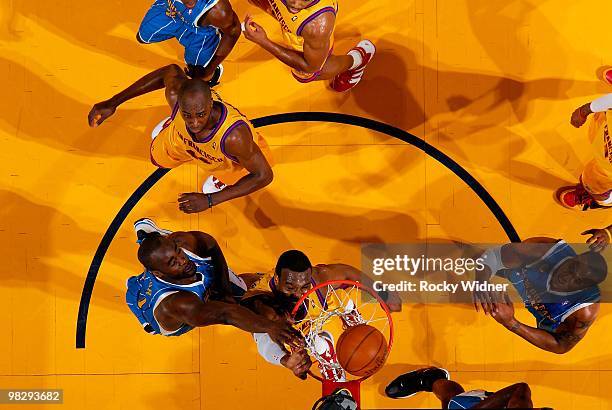 Chris Hunter of the Golden State Warriors slam dunks over Emeka Okafor of the New Orleans Hornets during the game on March 17, 2009 at Oracle Arena...