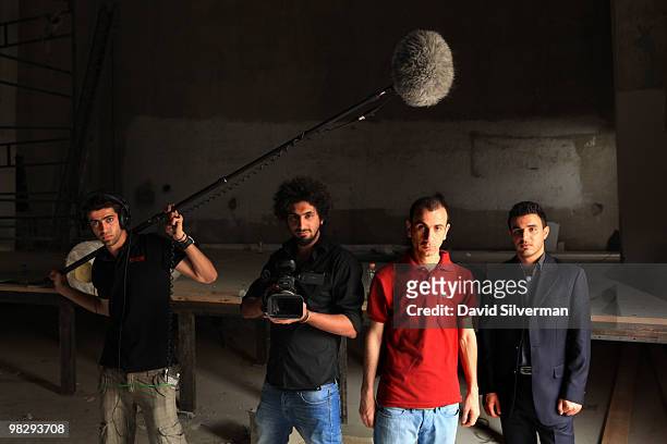 Palestinian staff of the Cinema Jenin project pose for a promotional documentary inside the city's old movie theatre on March 15, 2010 in Jenin, West...