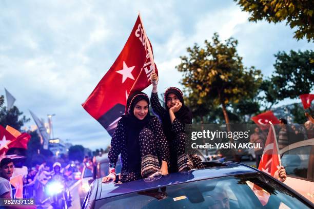 People wave flags outside the Justice and Development Party headquarters in Istanbul, on June 24 during the Turkish presidential and parliamentary...