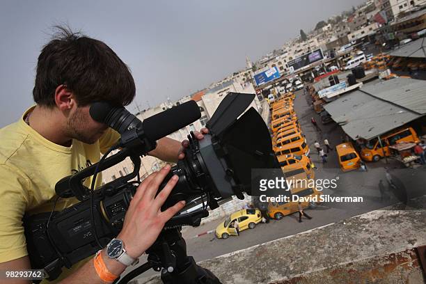 German cameraman Michele Gentile takes footage of the town for a documentary on the Cinema Jenin project from the roof of the city's old movie...