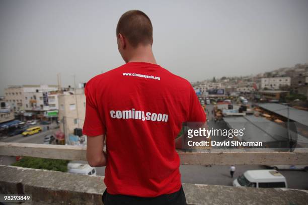 German volunteer Felix Gebauer carries building supplies on the roof of the city's old movie theatre on March 15, 2010 in Jenin, West Bank. Matthias...