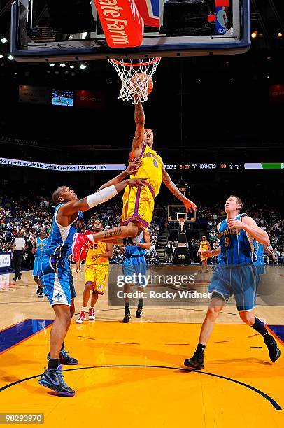 Monta Ellis of the Golden State Warriors lays the ball up over David West and Darius Songaila of the New Orleans Hornets during the game on March 17,...