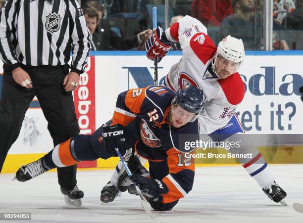 Tomas Plekanec of the Montreal Canadiens knocks down Josh Bailey of the New York Islanders off the faceoff at Nassau Coliseum on April 6, 2010 in...