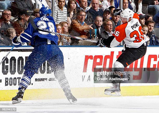 Colton Orr of the Toronto Maple Leafs hits Darroll Powe of the Philadelphia Flyers during an NHL game at the Air Canada Centre April 6, 2010 in...