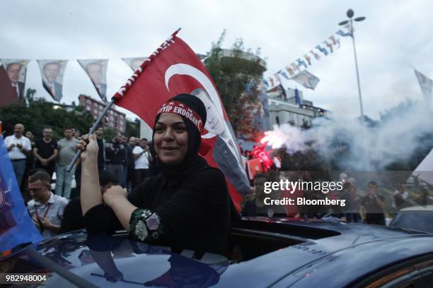 Woman waves Turkish national flags outside of the AKP party headquarters as they react to the outcome of the parliamentary and presidential elections...