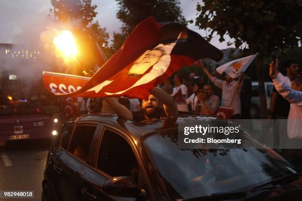 Man waves a Turkish national flag while traveling in a vehicle outside of the AKP party headquarters as they react to the outcome of the...