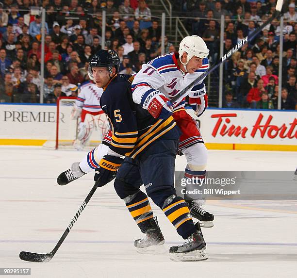 Brandon Dubinsky of the New York Rangers leaps to go around Toni Lydman of the Buffalo Sabres on April 6, 2010 at HSBC Arena in Buffalo, New York.