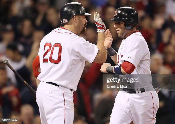 Dustin Pedroia of the Boston Red Sox is congratulated by Kevin Youkilis after Pedroia scored in the fifth inning against the New York Yankees on...