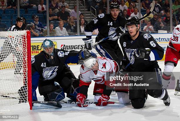 Sergei Samsonov of the Carolina Hurricanes is surrounded by Kurtis Foster, Andrej Meszaros, and goaltender Mike Smith of the Tampa Bay Lightning...