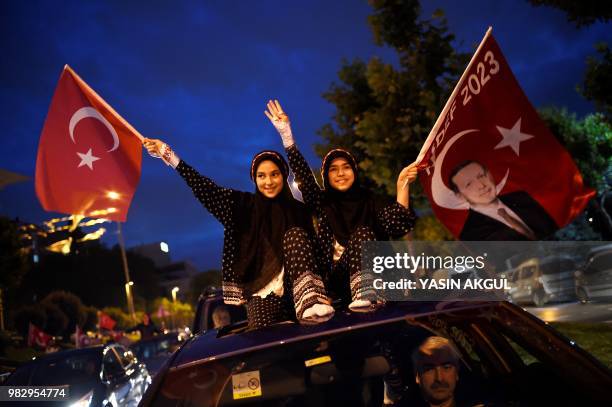 People wave flags outside the Justice and Development Party headquarters in Istanbul, on June 24 during the Turkish presidential and parliamentary...