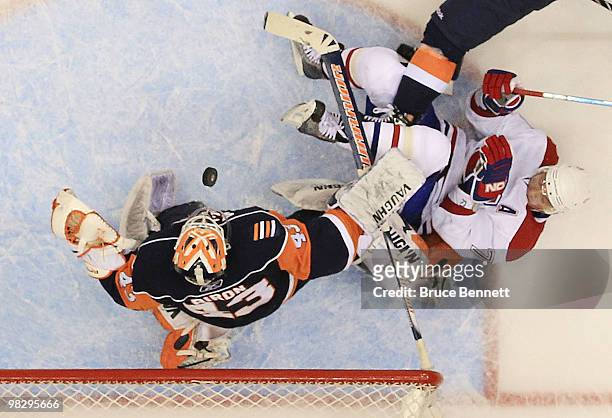 Andrei Markov of the Montreal Canadiens is knocked down in the crease as Martin Biron of the New York Islanders comes up with the puck at Nassau...
