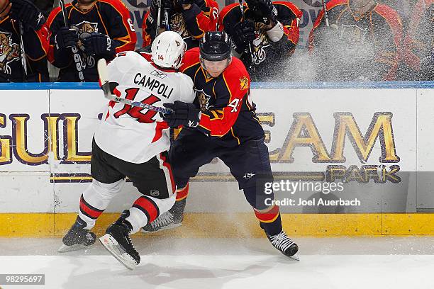 Chris Campoli of the Ottawa Senators and Dmitry Kulikov of the Florida Panthers fight along the boards on April 6, 2010 at the BankAtlantic Center in...