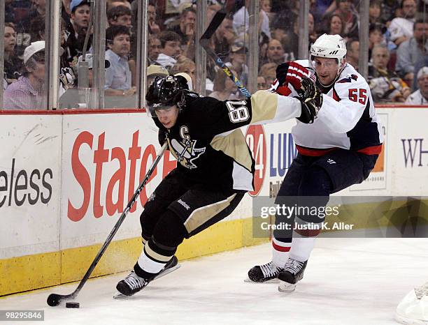 Sidney Crosby of the Pittsburgh Penguins handles the puck around Jeff Schultz of the Washington Capitals in the third period at Mellon Arena on April...