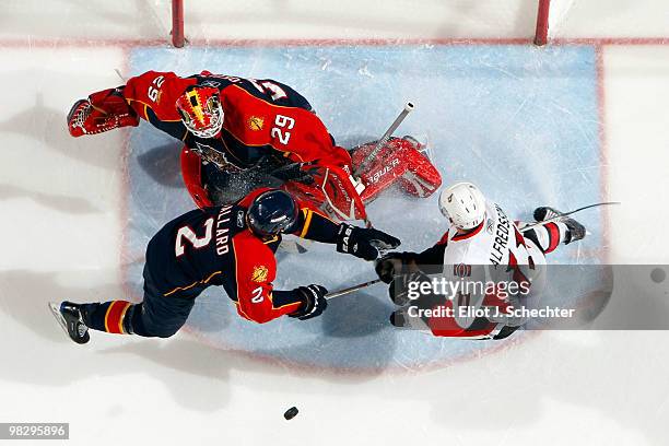 Goaltender Tomas Vokoun of the Florida Panthers defends the net with the help of teammate Keith Ballard against Daniel Alfredsson of the Ottawa...