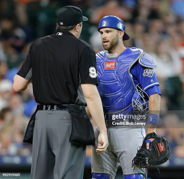 Drew Butera of the Kansas City Royals talks with home plate umpire Lance Barrett after being called for catcher interference in the second inning at...