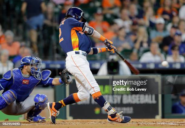 Josh Reddick of the Houston Astros singles in the second inning as Drew Butera of the Kansas City Royals looks on at Minute Maid Park on June 24,...