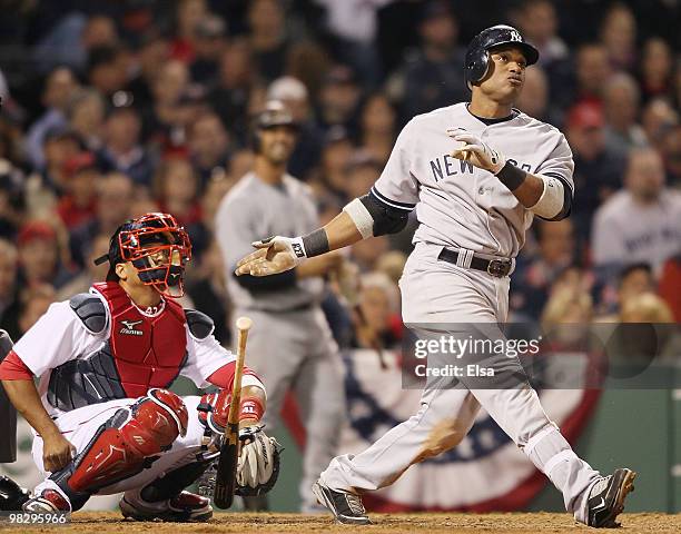 Robinson Cano of the New York Yankees watches his solo home run in the ninth inning as catcher Victor Martinez of the Boston Red Sox defends on April...