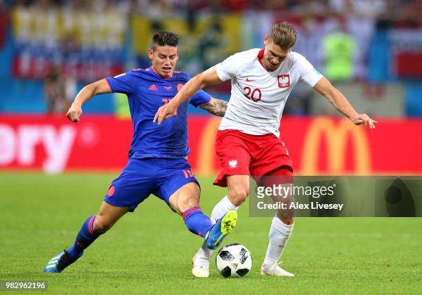 Lukasz Piszczek of Poland is challenged by James Rodriguez of Colombia during the 2018 FIFA World Cup Russia group H match between Poland and...