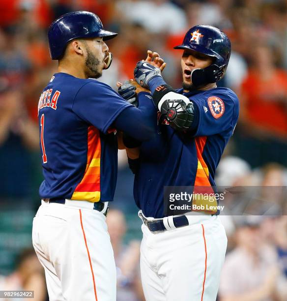 Yuli Gurriel of the Houston Astros celebrates with Carlos Correa after Gurriel's grand slam in the second inning against the Kansas City Royals at...
