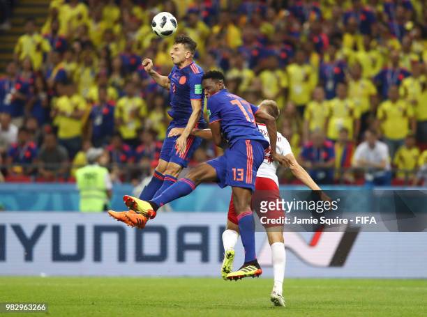 Santiago Arias of Colombia wins a header over Yerry Mina of Colombia and Lukasz Teodorczyk of Poland during the 2018 FIFA World Cup Russia group H...