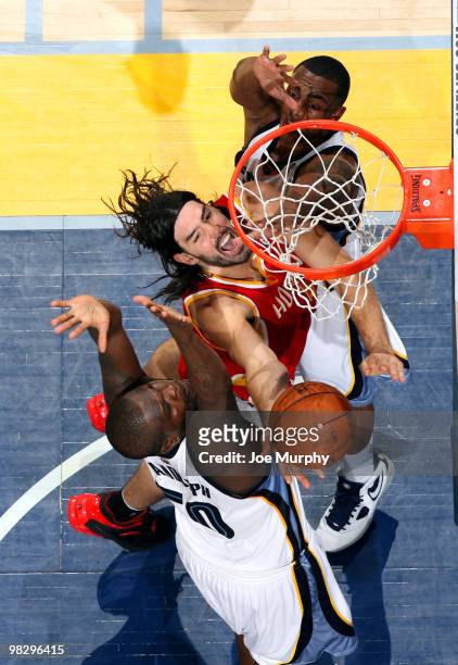 Luis Scola of the Houston Rockets shoots a layup between Zach Randolph and Darrell Arthur of the Memphis Grizzlies on April 06, 2010 at FedExForum in...