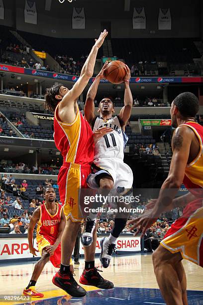 Mike Conley of the Memphis Grizzlies shoots around Luis Scola of the Houston Rockets on April 06, 2010 at FedExForum in Memphis, Tennessee. NOTE TO...